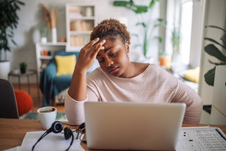 troubled remote worker at home sitting in front of laptop